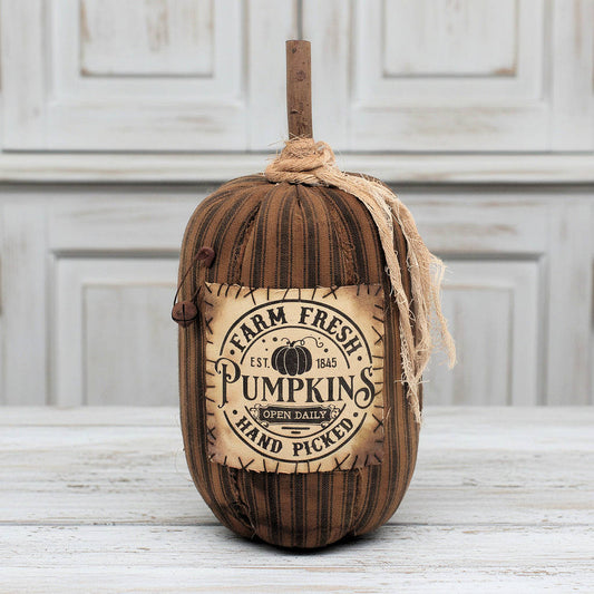 Decorative pumpkin with 'Farm Fresh Pumpkins' label on a wooden surface