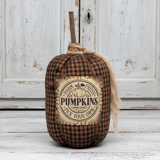 Decorative pumpkin with plaid pattern and 'Farm Fresh Pumpkins' label on a wooden background