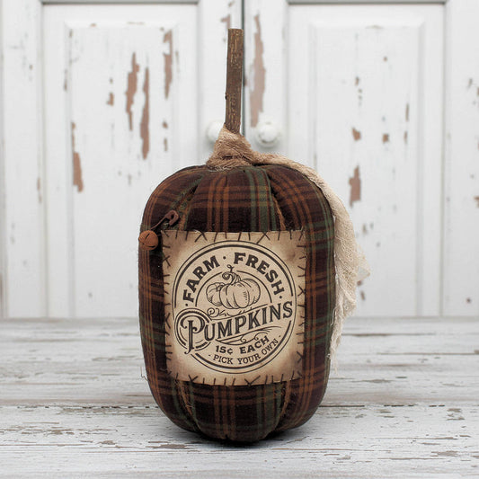 Decorative pumpkin with 'Farm Fresh Pumpkins' label on a wooden surface