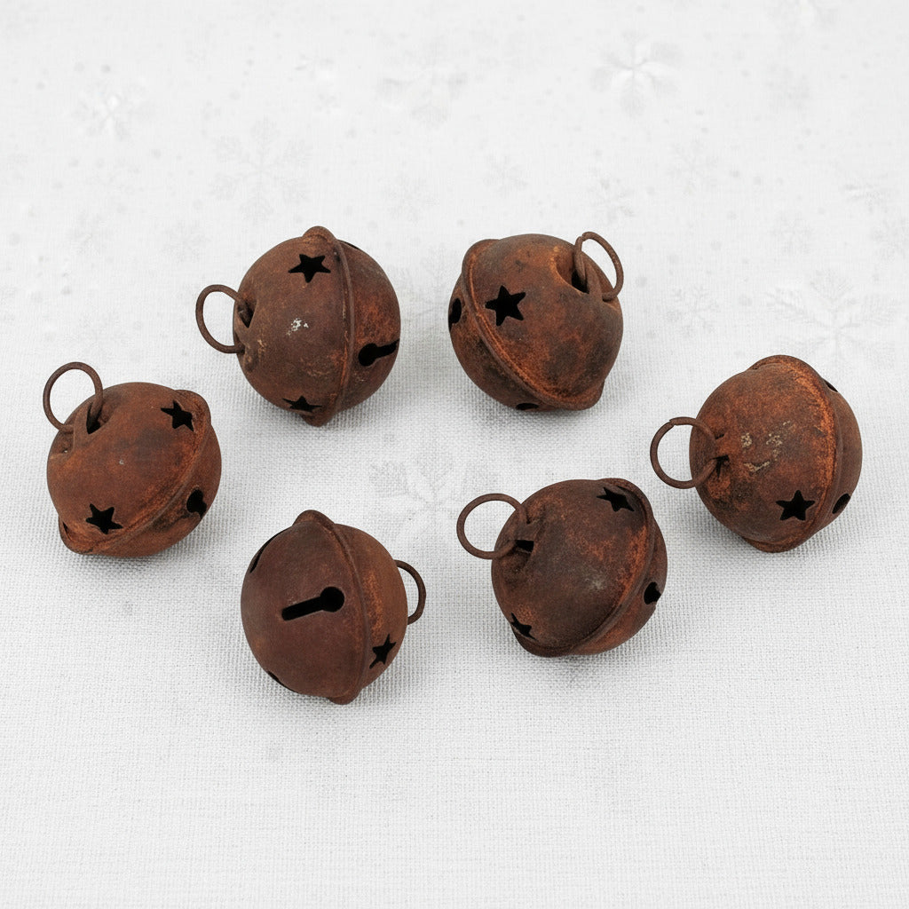 Set of six rusted metal bells on a white background