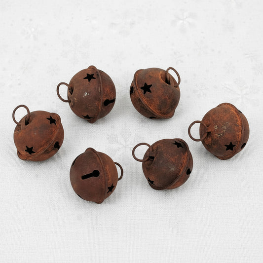 Set of six rusted metal bells on a white background