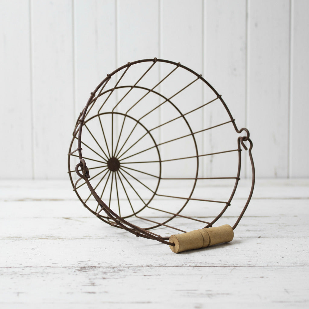Decorative metal egg basket with a wooden handle on a white background