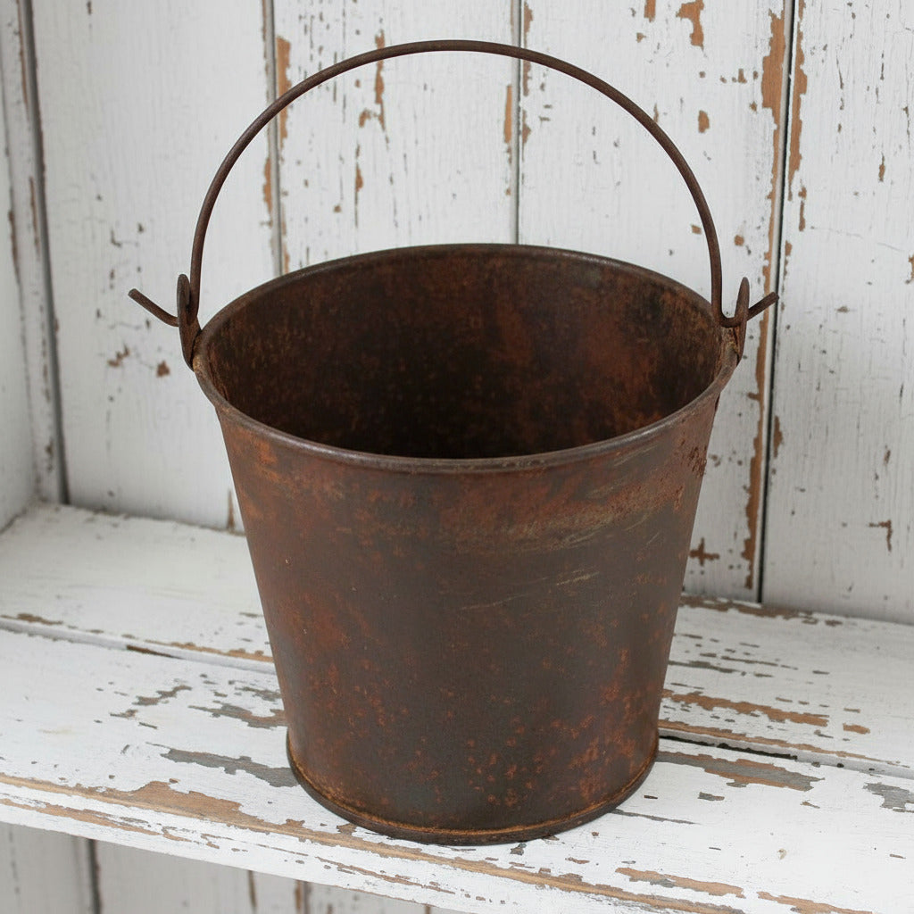 Rustic metal bucket with a handle on a white background
