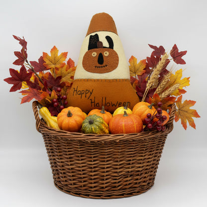 Decorative basket with pumpkins, gourds, and a cornucopia-shaped Halloween decoration on a white background.