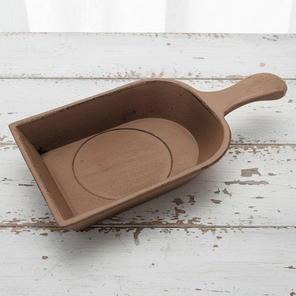 Brown scoop candle holder with a handle on a white background