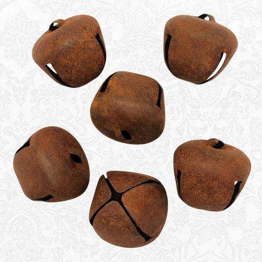 Set of six rusted metal bells on a white background