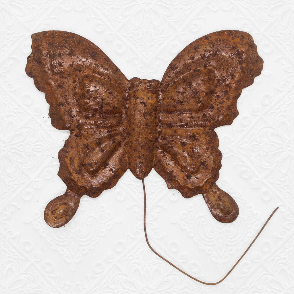 Rust-colored butterfly decorative item on a white background