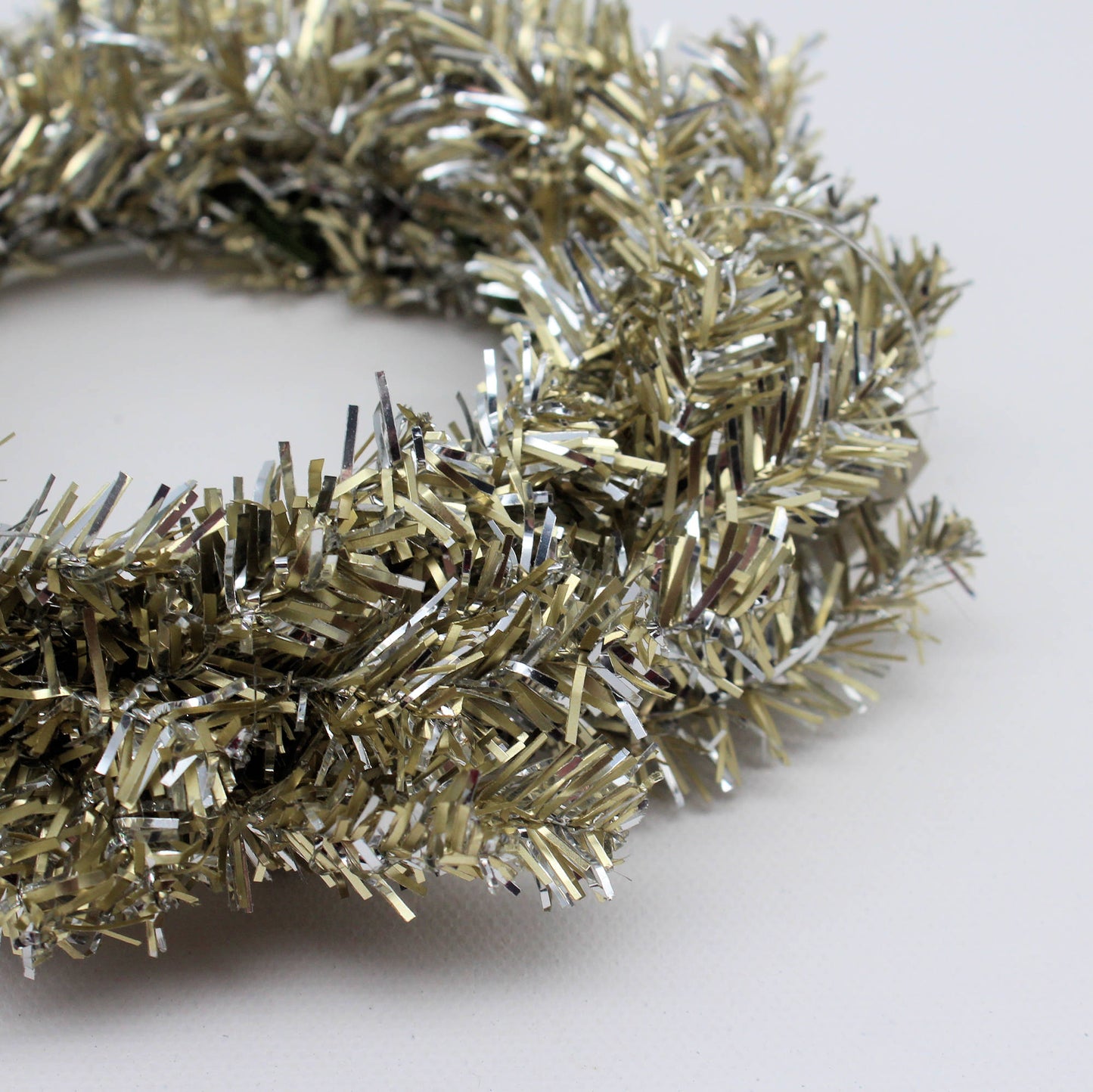 Gold and silver tinsel candle ring on a white background