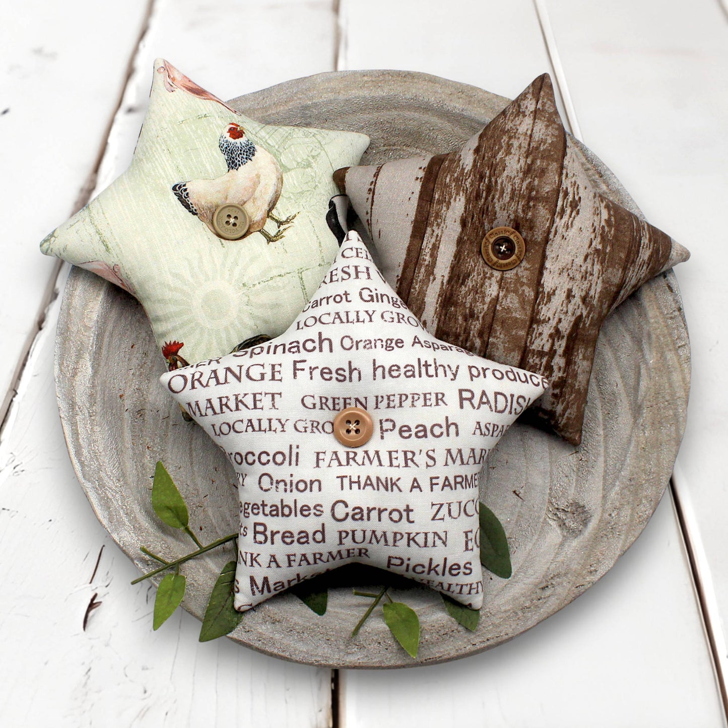 Three decorative stars bowl fillers with rustic designs on a wooden plate.