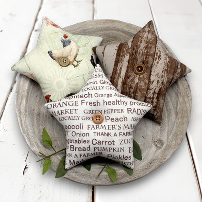 Three decorative stars bowl fillers with rustic designs on a wooden plate.