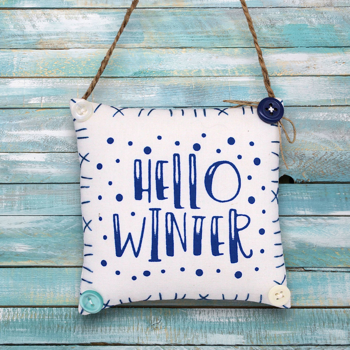 Decorative sign ornament with 'Hello Winter' text on a wooden background