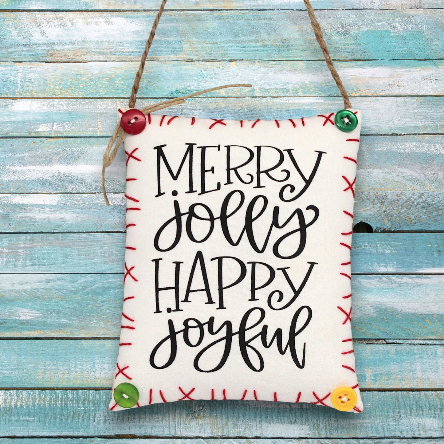 Decorative sign ornament with 'Merry Jolly Happy Joyful' text on a wooden background