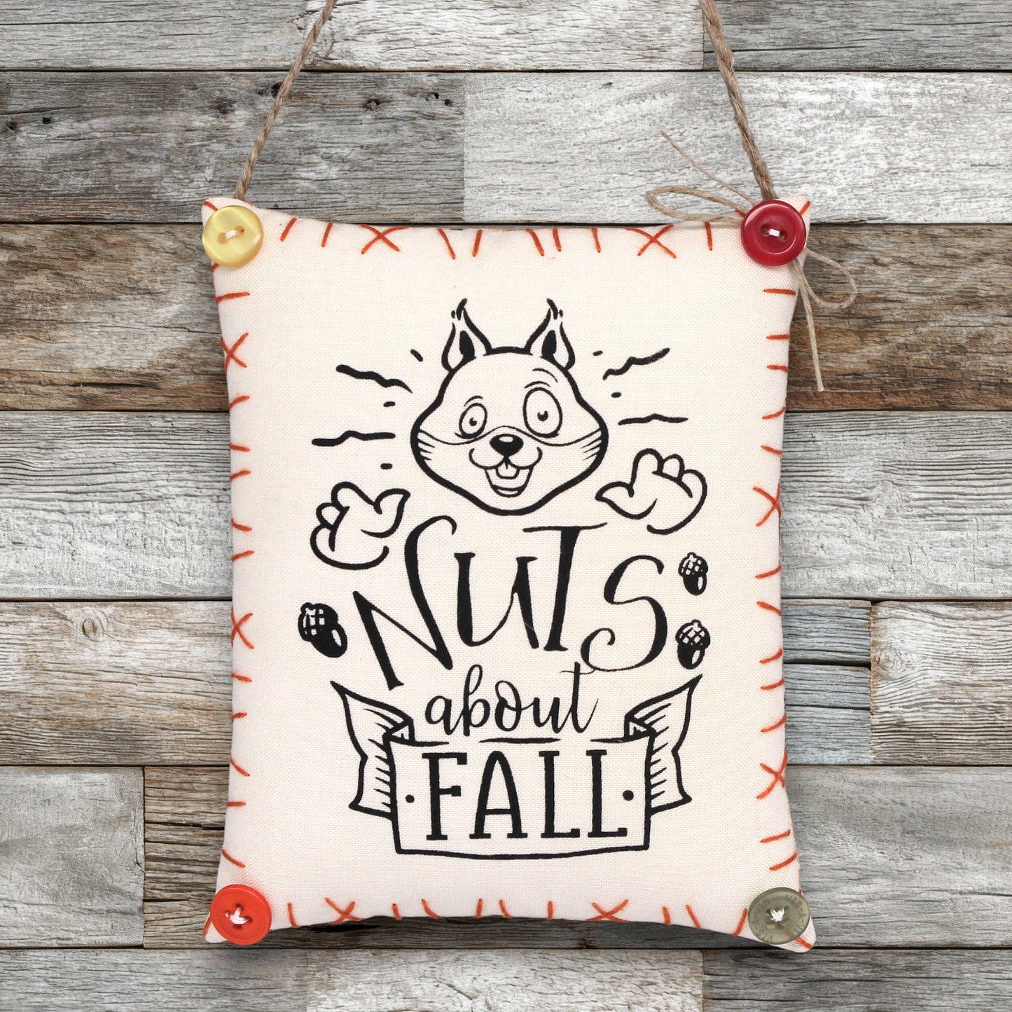 Fabric sign ornament with a happy squirrel and text that reads 'nuts about fall'