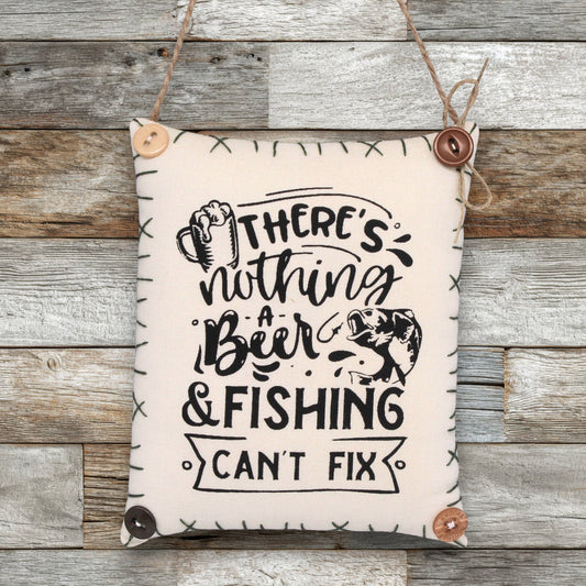Decorative sign ornamnet with text 'There's nothing a beer & fishing can't fix' on a wooden background