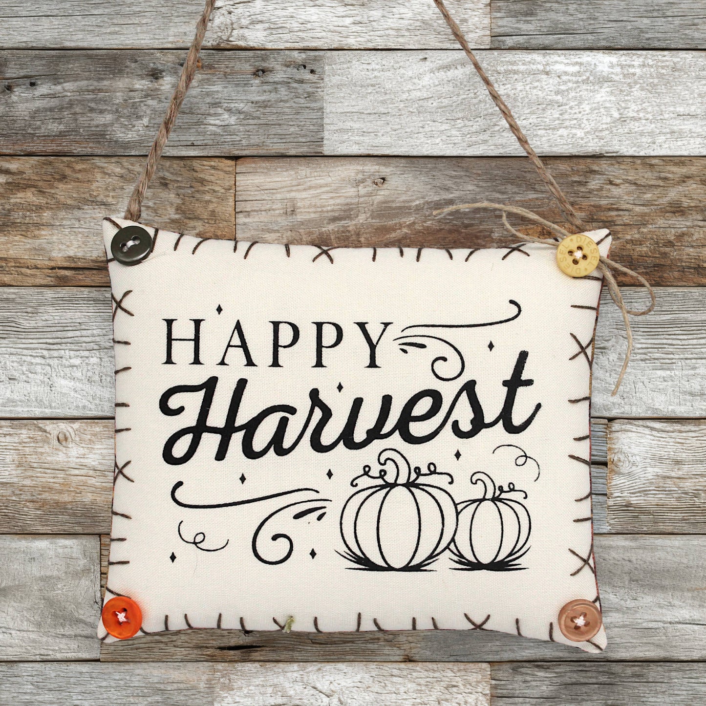 Decorative sign ornament with 'Happy Harvest' text and pumpkins on a wooden background
