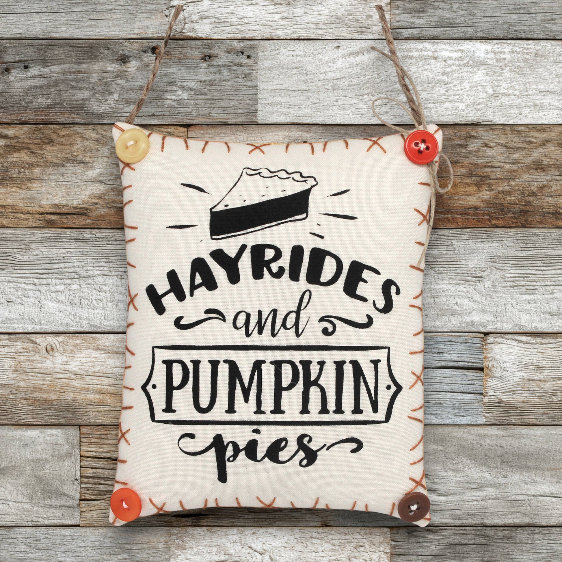 Decorative sign ornament with 'Hayrides and Pumpkin Pies' text on a wooden background