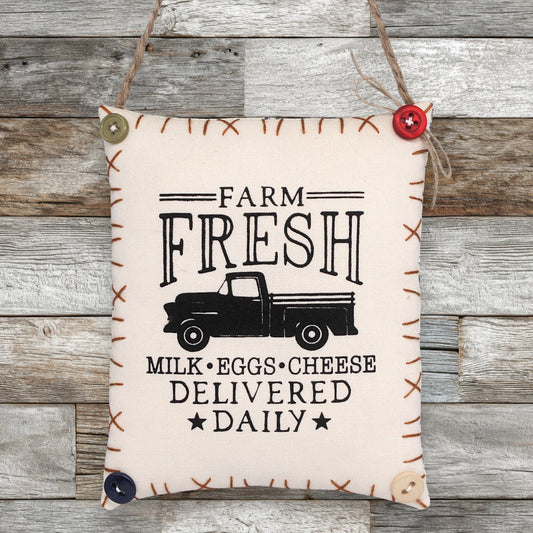 Decorative sign ornament with 'Farm Fresh' text and truck graphic on a wooden background
