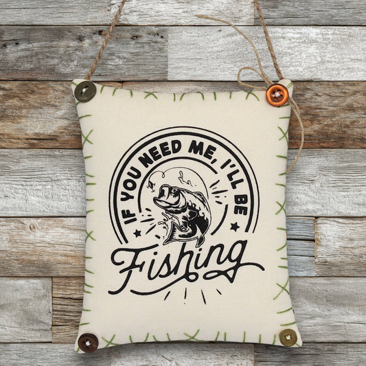 Decorative sign ornament with fishing-themed text and graphics on a wooden background