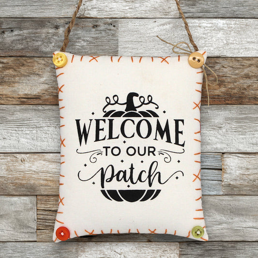 Decorative sign ornament with 'Welcome to our patch' text on a wooden background