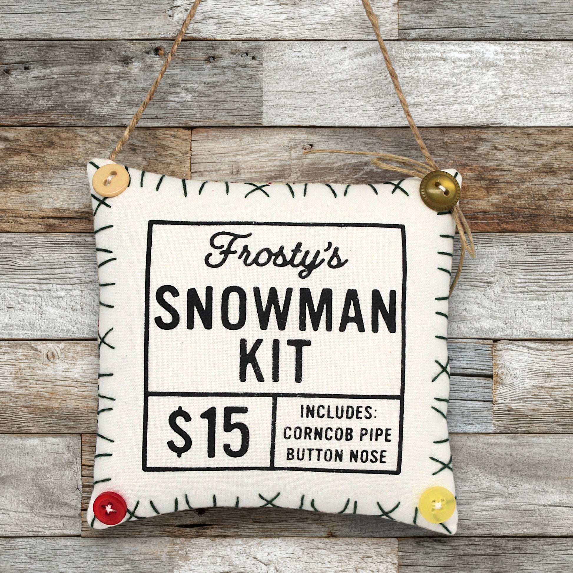 Frosty's Snowman Kit ornament sign on a wooden background