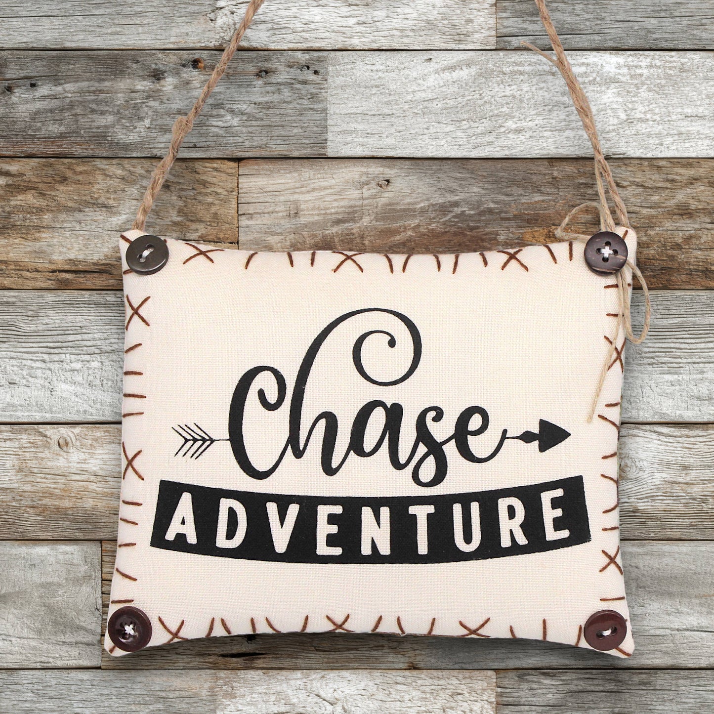 Fabric sign ornament with 'Chase Adventure' text on a wooden background