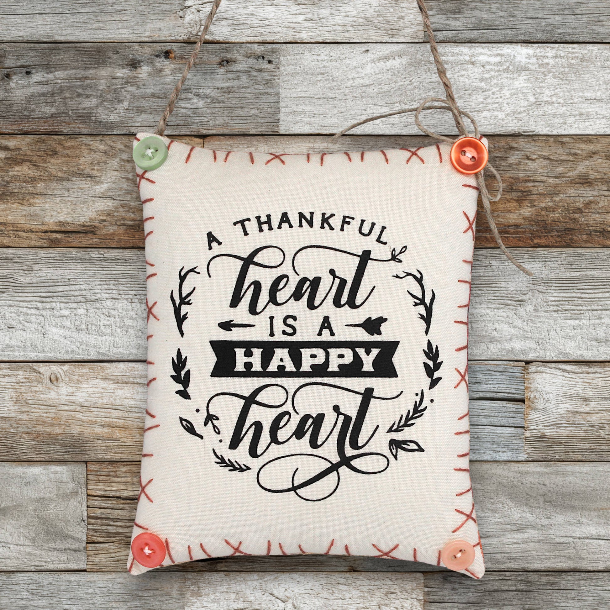 Decorative sign ornament with 'A thankful heart is a happy heart' text on a wooden background