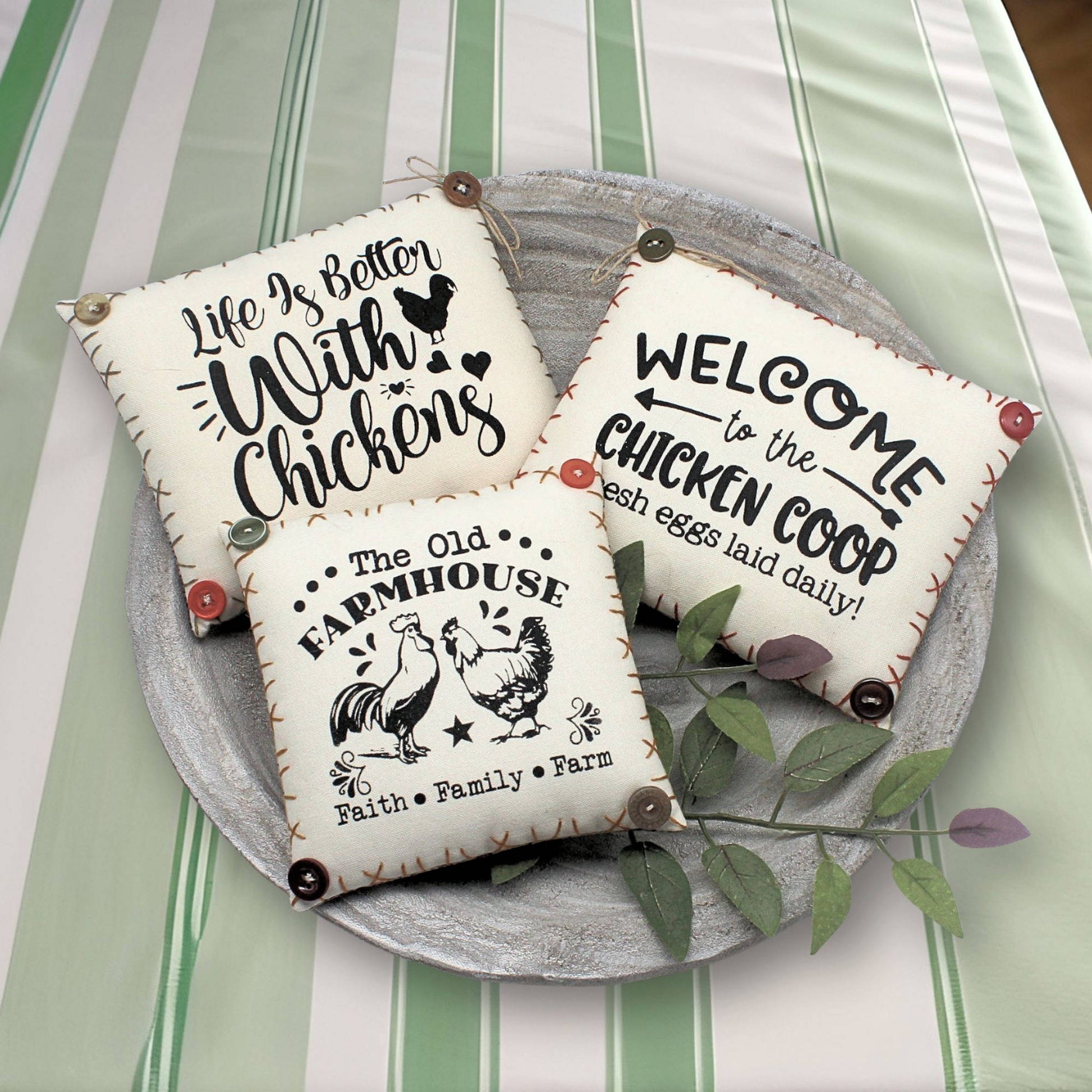 Three decorative mini pillow bowl fillers with chicken-themed sayings on a striped background