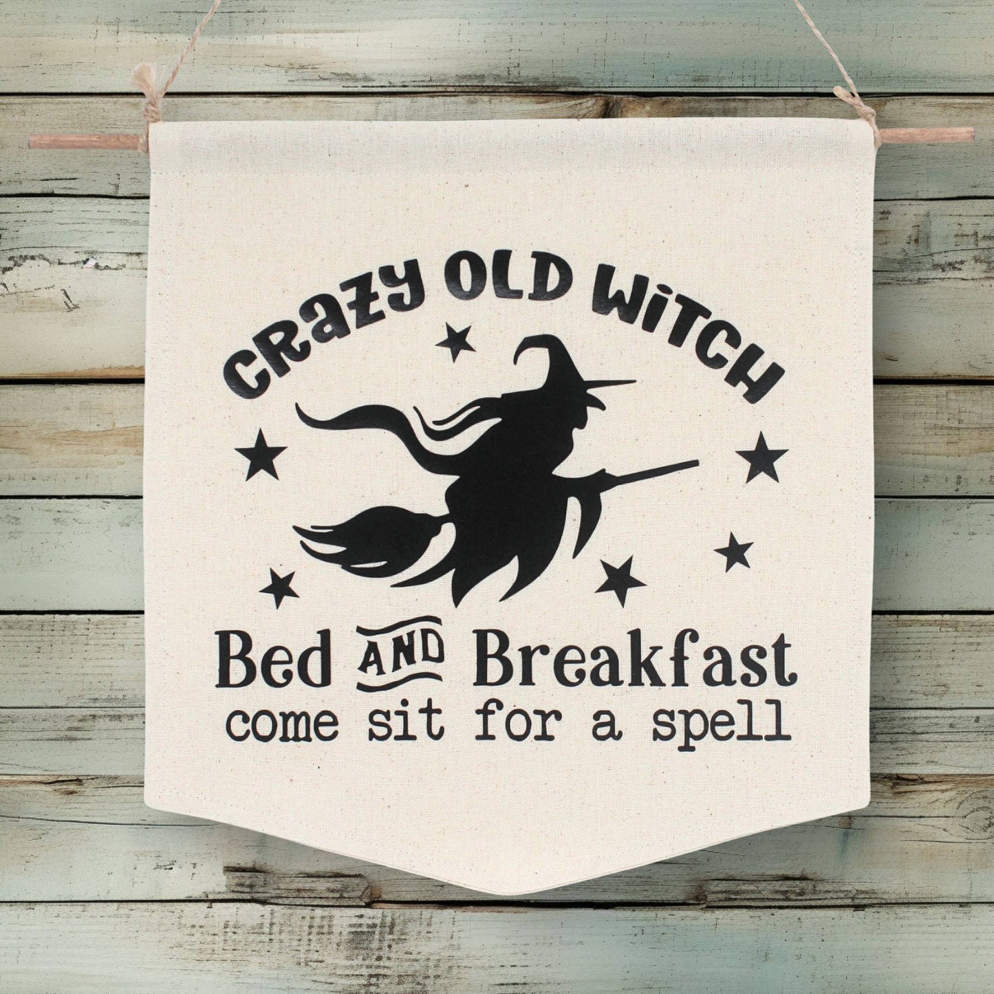 Handcrafted muslin wall banner with vinyl lettering that advertises for the Crazy Old Witch Bed and Breakfast