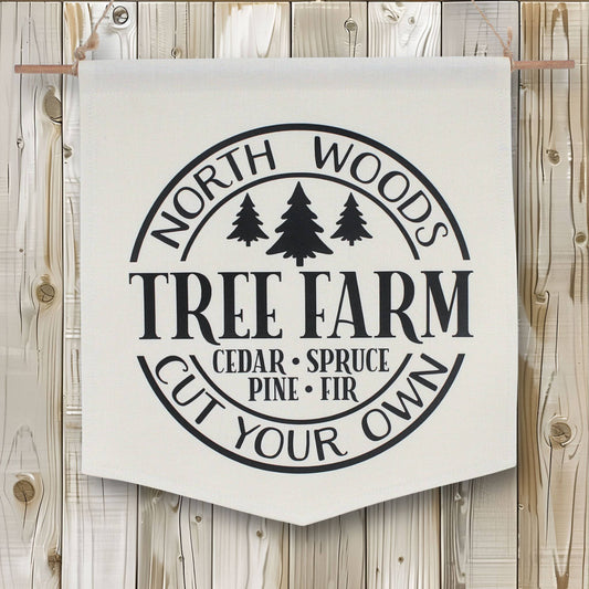 Fabric banner with 'North Woods Tree Farm' text and tree illustrations on a wooden background