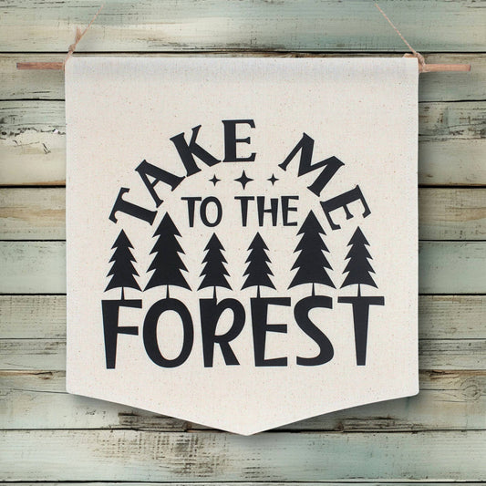 Fabric banner with 'Take Me to the Forest' text and tree graphics on a wooden background