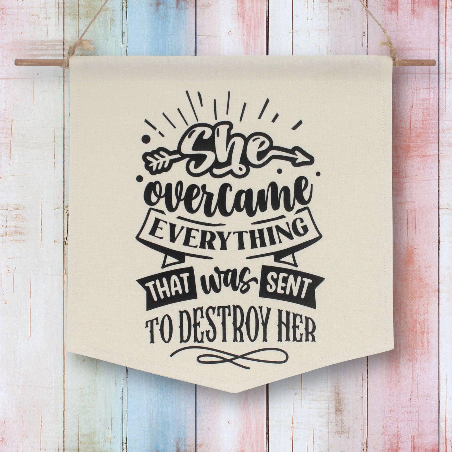 Fabric wall banner which reads 'she overcame everything that was sent to destroy her'