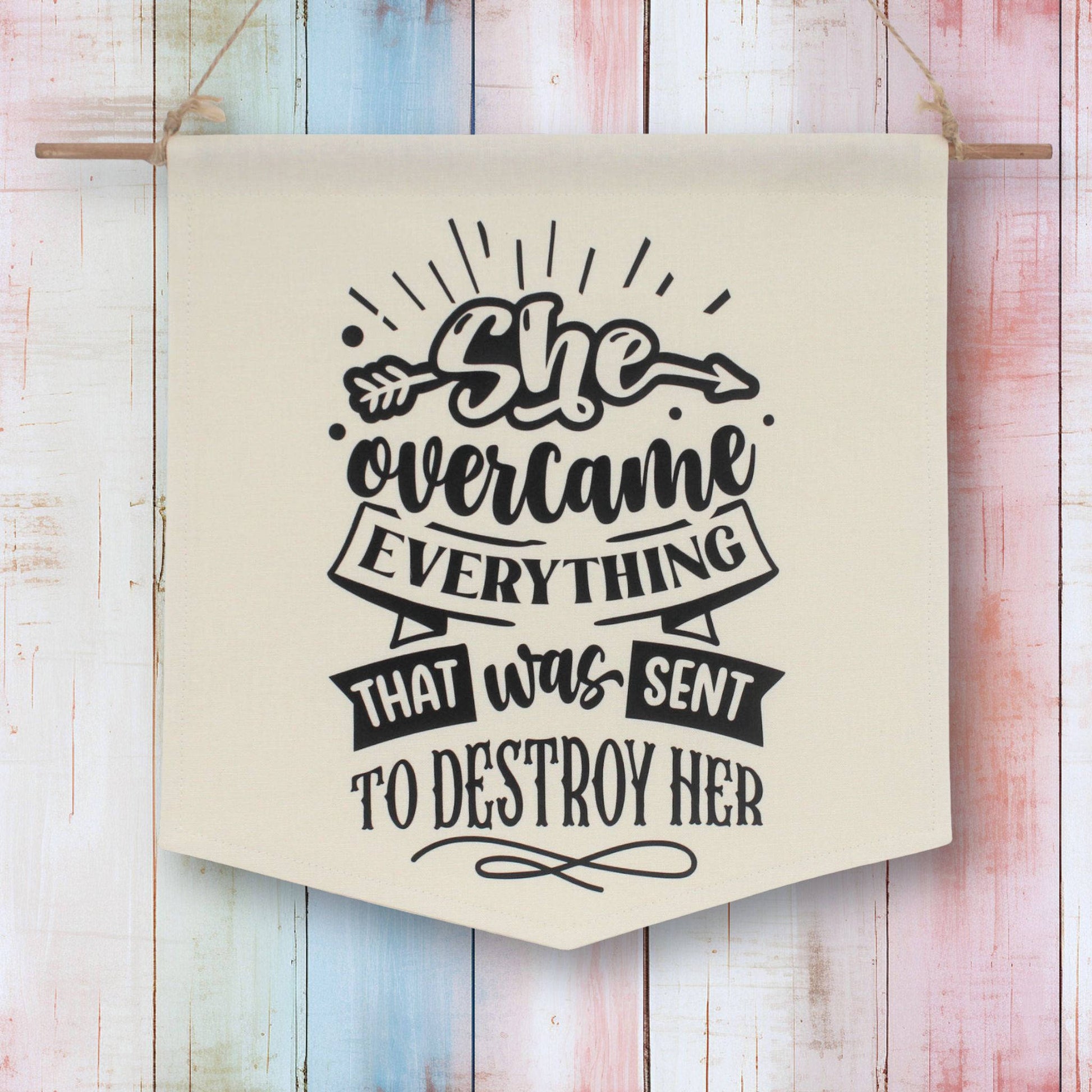 Fabric wall banner which reads 'she overcame everything that was sent to destroy her'