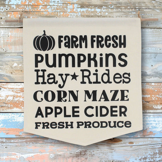 Fabric wall banner with text that reads 'farm fresh pumpkins, hay rides, corn maze, apple cider, fresh produce'