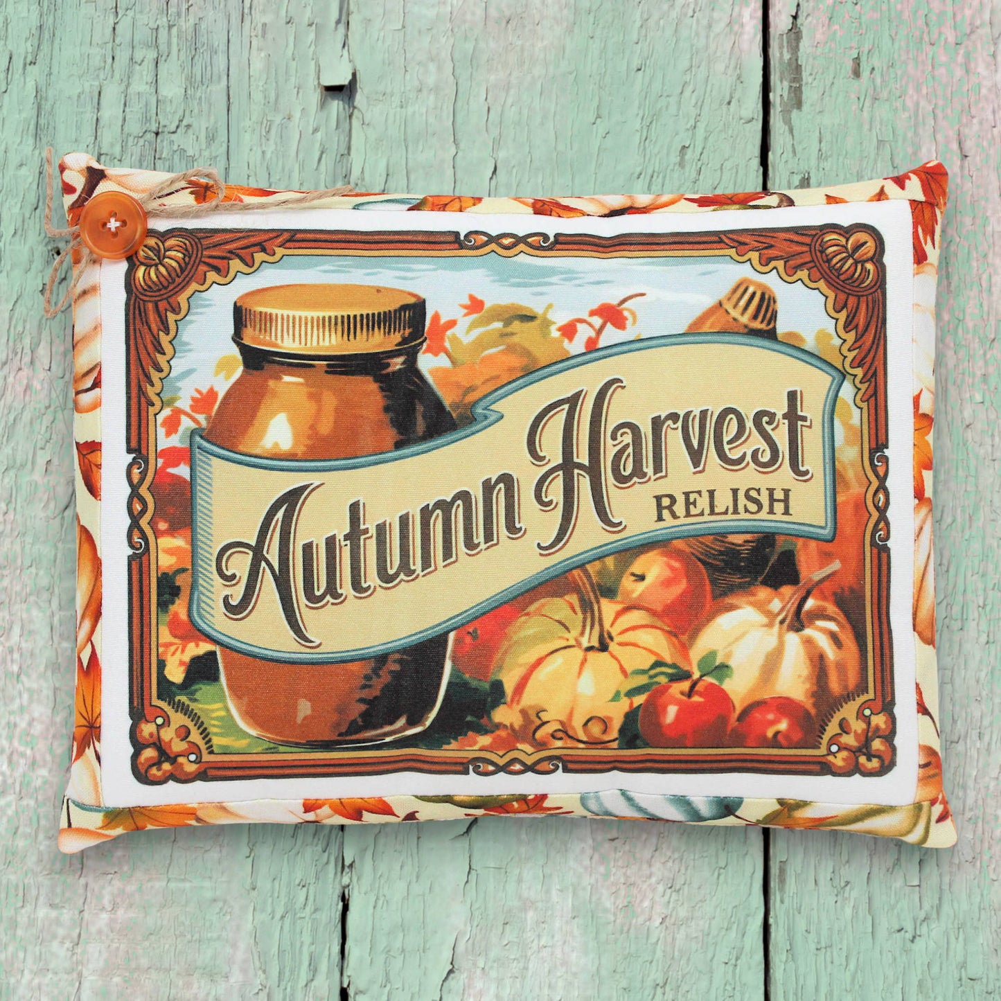Decorative pillow with 'Autumn Harvest Relish' design on a wooden surface