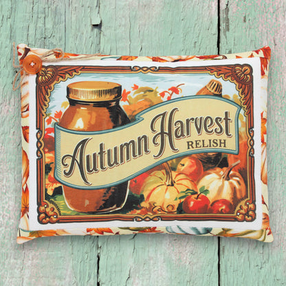 Decorative pillow with 'Autumn Harvest Relish' design on a wooden surface