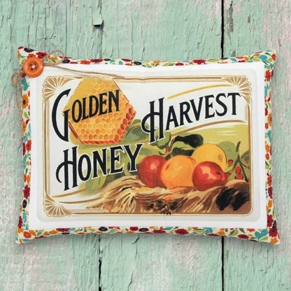 Small decorative pillow featuring a colorful golden harvest honey design