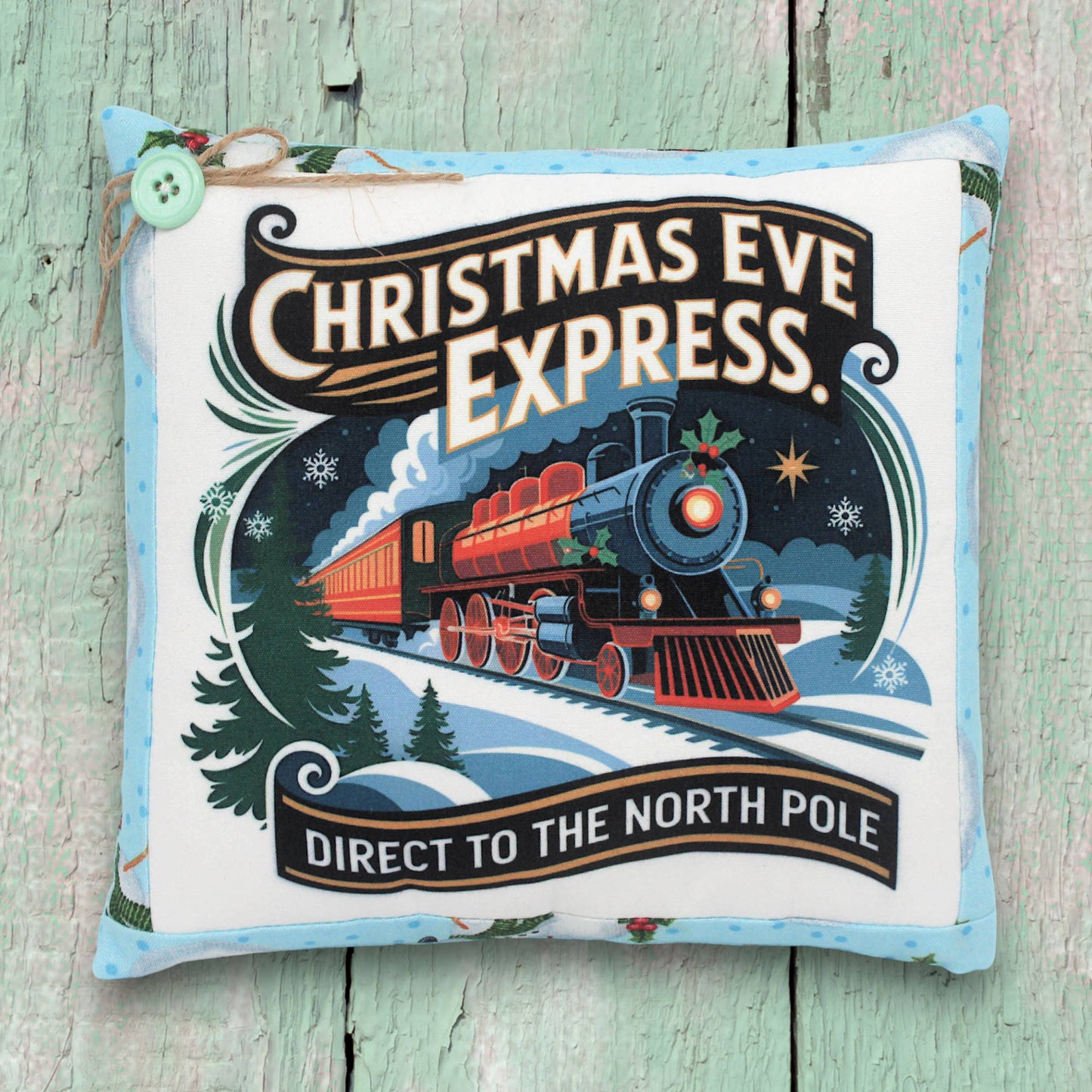 Decorative pillow with Christmas Eve Express train design on a wooden surface