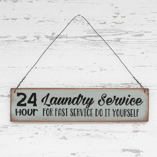 Small wooden sign that reads '24 hour laundry service, for fast service do it yourself'