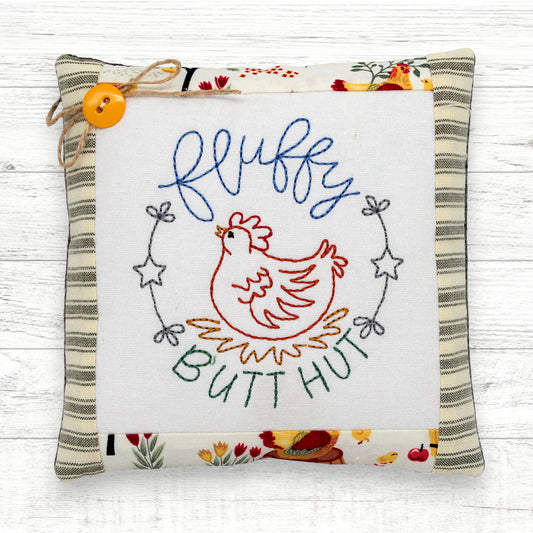 Primitive farmhouse style mini pillow or cupboard tuck embroidered with a chicken and the text 'fluffy butt hut'